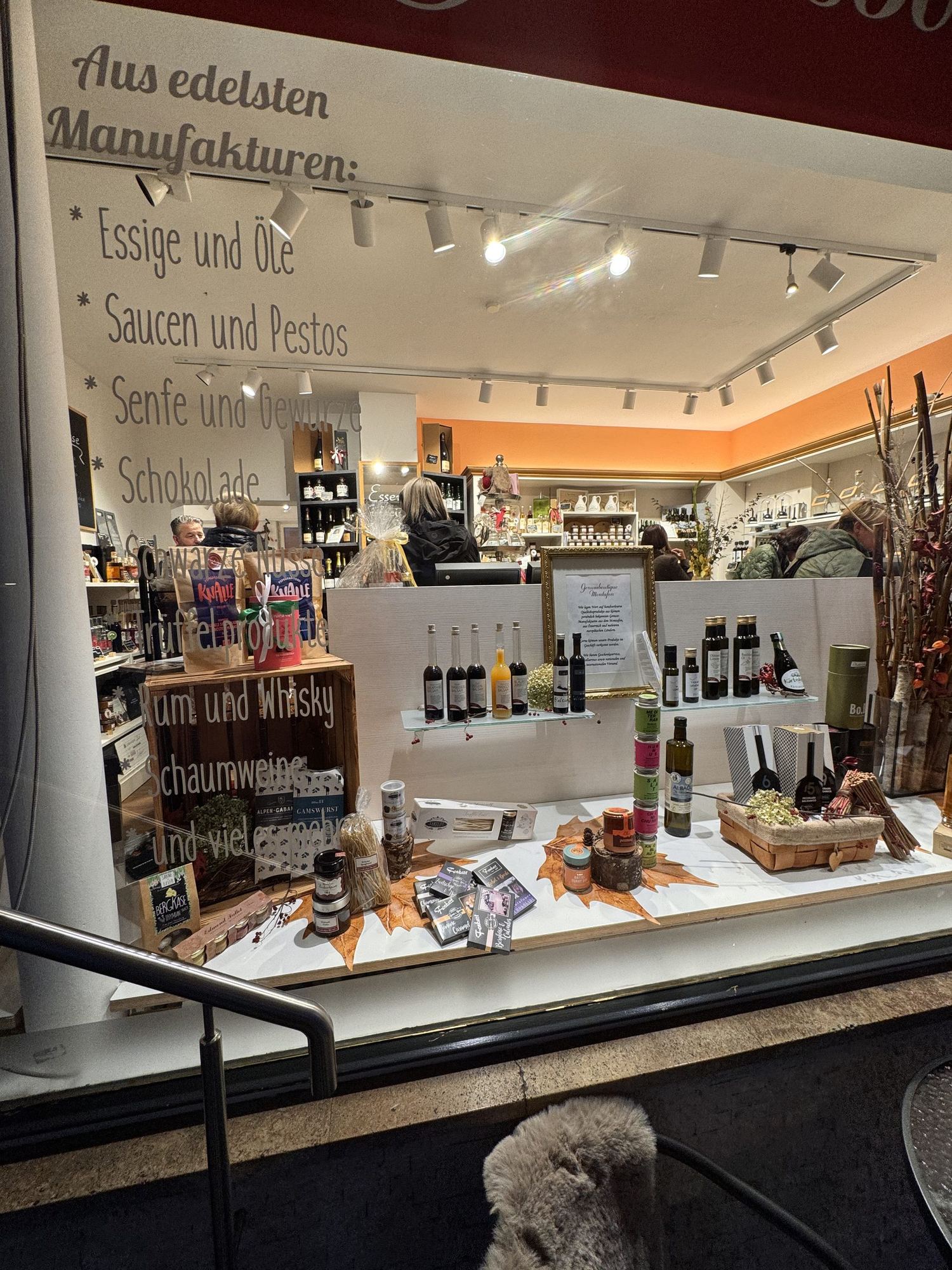 Schaufenster der Boutique am Abend mit ausgestellten Ölen, Essigen und Geschenkideen